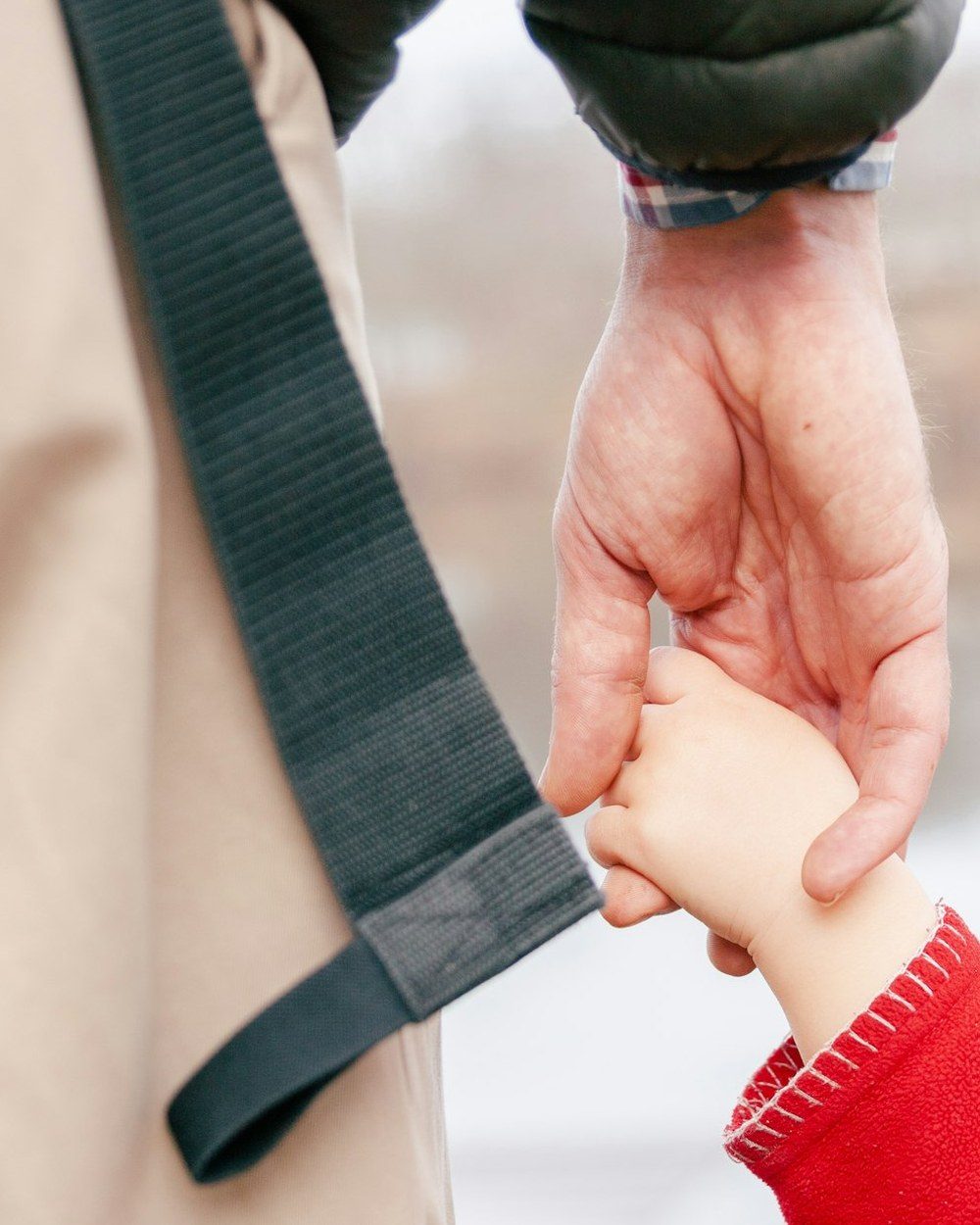 An adult hand holding a small child&rsquo;s hand